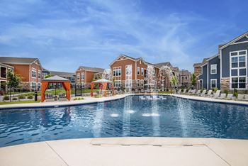 an outdoor swimming pool with apartments in the background  at Watermark on Twenty Mile, Parker, CO, 80134